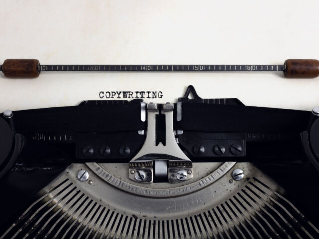 Old retro vintage black typewriter with close-up typing text Copywriting as heading on aged paper